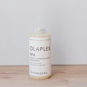 a bottle of olaplex on a wooden table