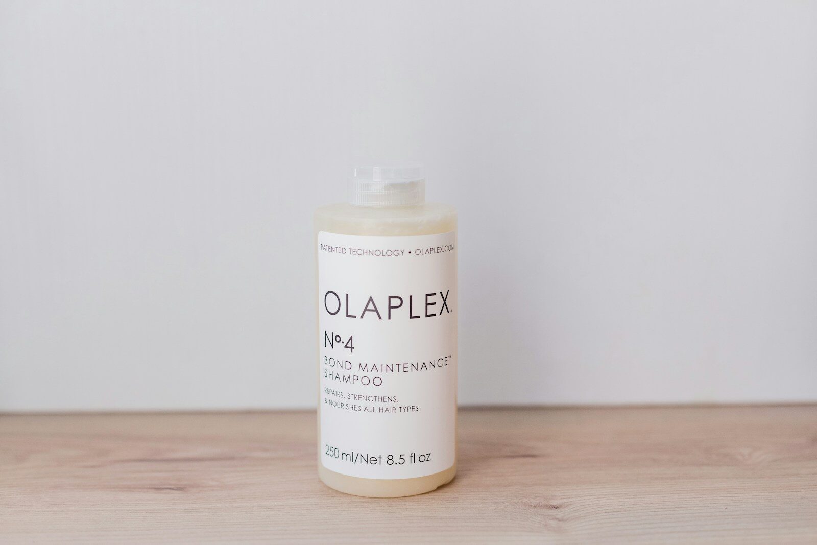a bottle of olaplex on a wooden table